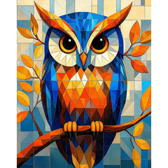 A paint by numbers canvas of a bold geometric owl built from blue, orange, and gold triangular facets, perched on a branch of autumn leaves.