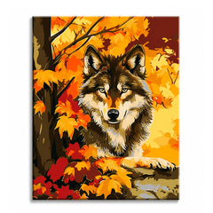 A wolf resting among gold and red autumn maple leaves at the foot of a tree, shown as a paint by numbers canvas.
