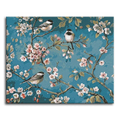 Three chickadees perched among blossoming branches against a muted teal background in a classic chinoiserie style, shown as a paint by numbers canvas.