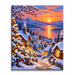 Along a snowy hillside, a Christmas village paint by numbers design shows decorated firs, glowing cottages, a church, and a reflective lake at mountain sunset.
