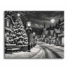 A black and white Christmas village paint by numbers design showing a snow-covered tree with a bright star, wreathed lampposts and a church spire along a snowy road toward distant mountains.