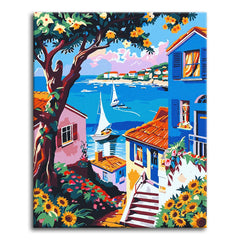 A paint by numbers canvas in bold illustrated style of a coastal bay with white sailboats, colorful hillside houses, a flowering tree, and sunflowers in the foreground.