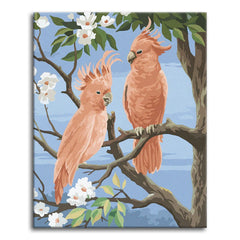 A paint by numbers scene of two pink cockatoos with raised crests on a blossoming branch against a blue sky.