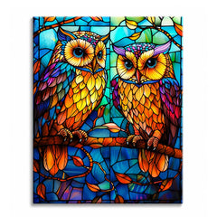 A paint by numbers canvas of two amber and gold owls on a branch in stained-glass style, set against panes of cobalt and teal.