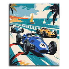 A bold vintage travel-poster style paint by numbers scene of three classic racing cars speeding along a coastal road, with sailboats on a turquoise sea, palm trees, and a seaside town in the background.